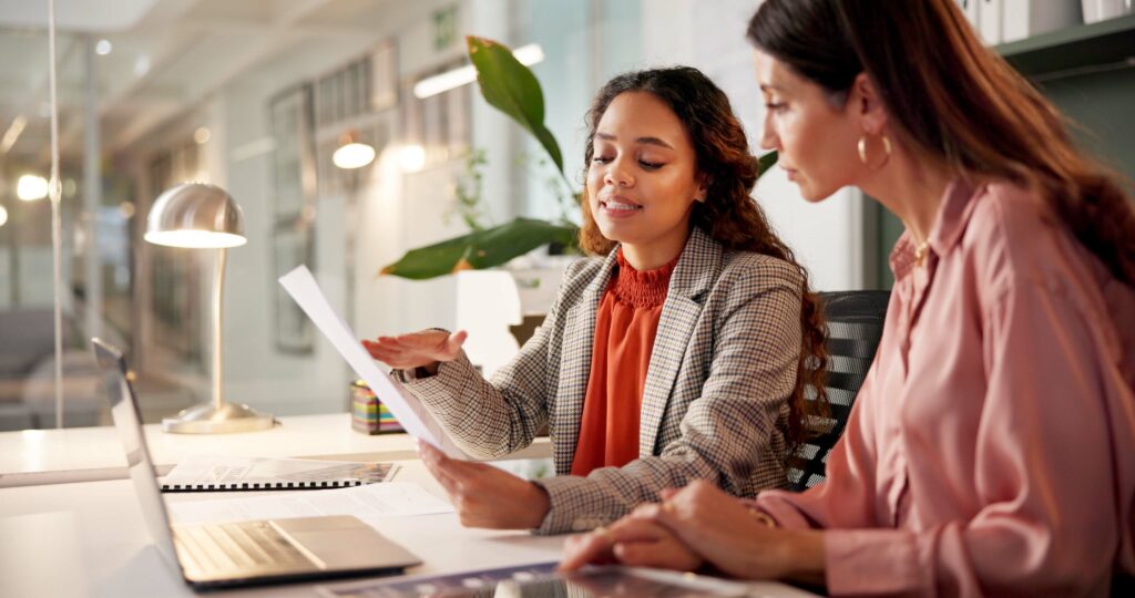 Planning reading and financial advisor with client for document investment discussion and tips Business office women team and talking with paperwork for policy review laptop or corporate meeting - Tradeinfo.cz Buy & Hold, Investice