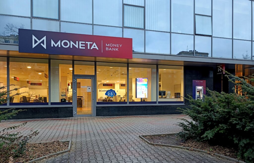 Moneta Money Bank with ATM and lights on in evening - Tradeinfo.cz - ForexMag.cz Moneta, Akcie