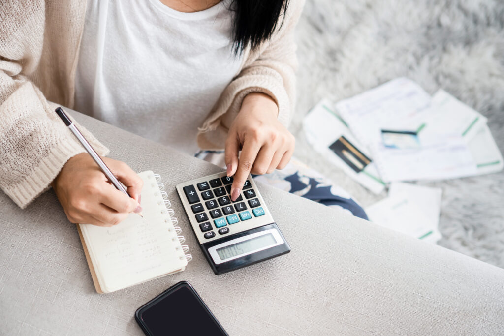 woman writing a list of debt on notebook calculating her expense - Tradeinfo.cz - ForexMag.cz Spořicí účet vs. investování