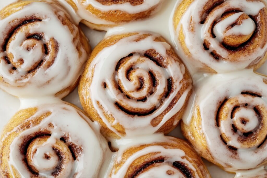 Freshly baked cinnamon rolls with creamy icing close-up - Tradeinfo.cz Cinnamood