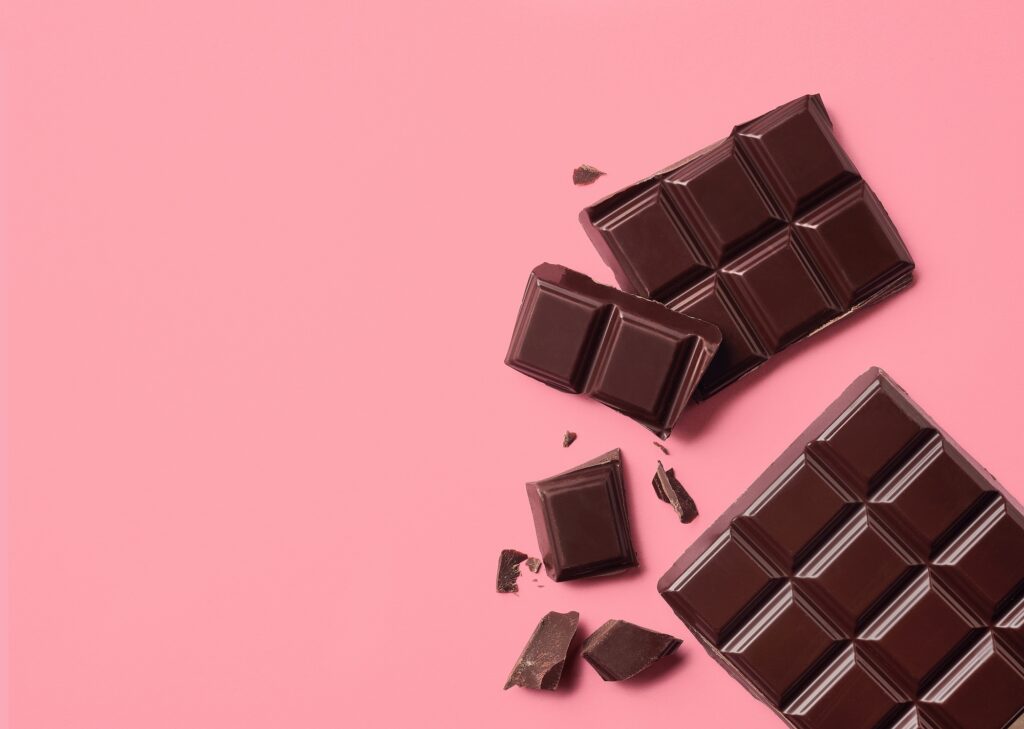 Dark chocolate on pink background Top view - Tradeinfo.cz Čokoláda - Choco Boss