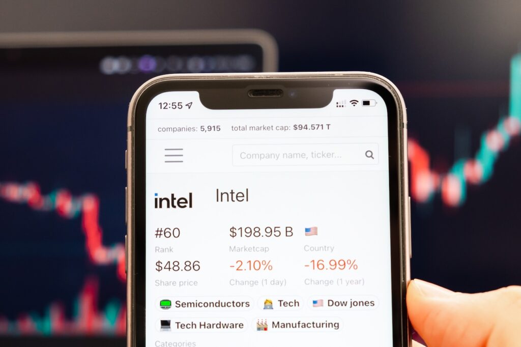 Akcie - Tradeinfo.cz Smartphone screen showing Intel stock data: ticker, market cap, price and change, with category tags below.