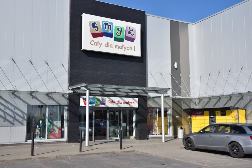 Obchod - Tradeinfo.cz Exterior of a toy store with colorful logo and Polish slogan in a shopping center entrance.