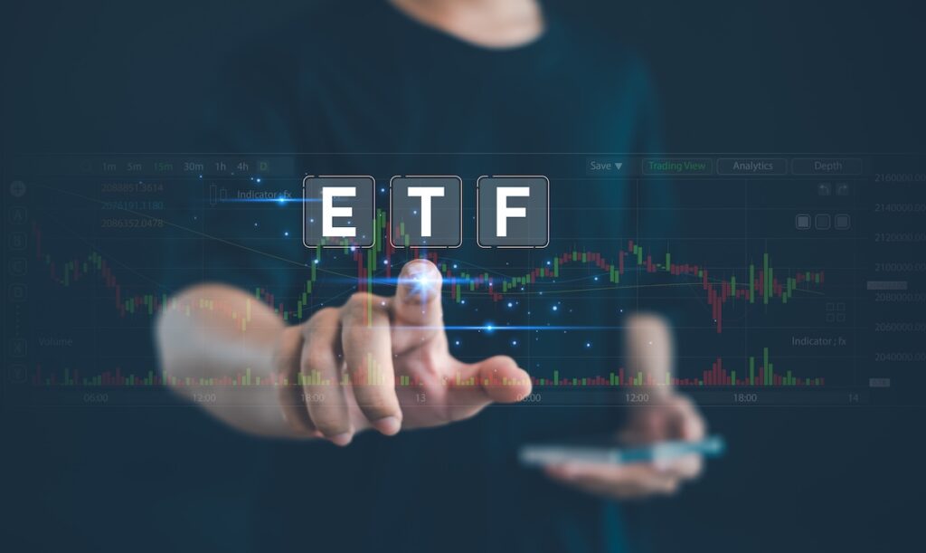 ETF11768 - Tradeinfo.cz Person touching a holographic ETF icon over a background of a stock trading chart.