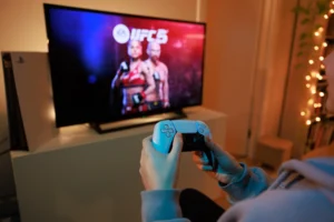 Hráč hraje EA Sports UFC 5 od firmy Electronic Arts na konzoli. Zdroj obrázku: Adobe Stock.