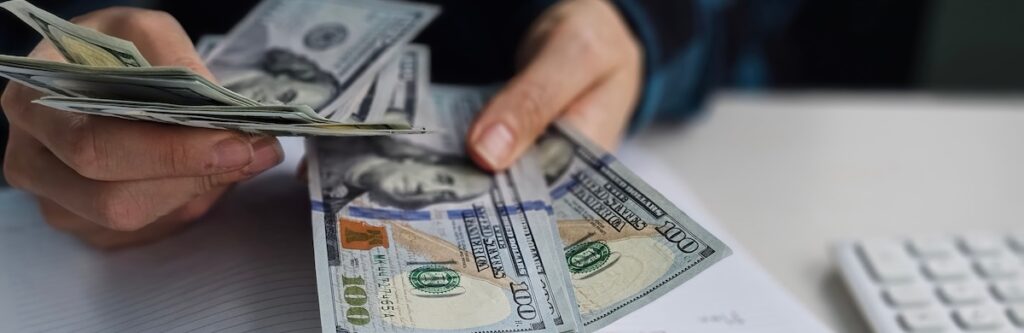 Counting cash and making financial notes in a workspace during the daytime - Tradeinfo.cz Berkshire Hathaway akcie